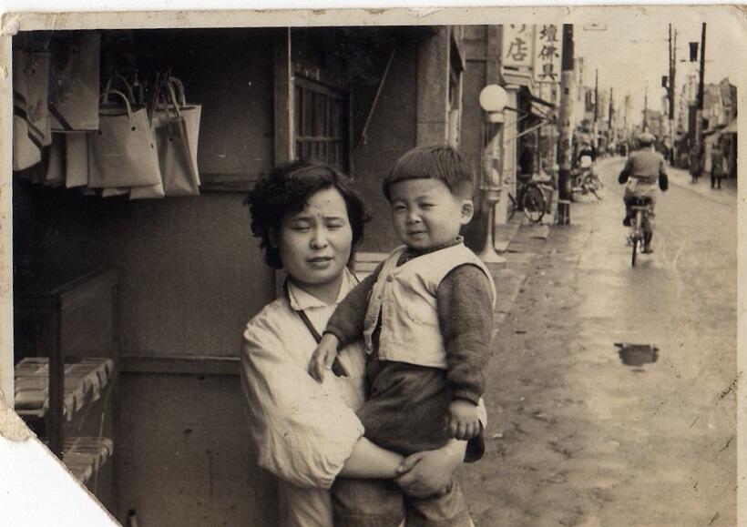 商店街で、お母さんに抱きかかえられた男の子（写真提供：としま南長崎トキワ荘協働プロジェクト協議会）